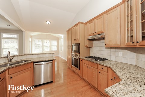 A kitchen with wooden cabinets and granite countertops.