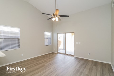 A spacious room with a ceiling fan and sliding glass doors.