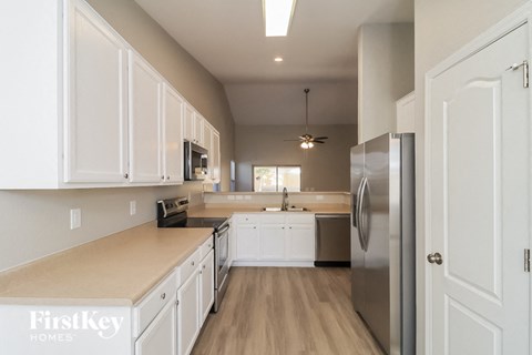 A kitchen with white cabinets and a stainless steel refrigerator.