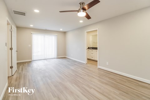 A spacious room with a ceiling fan and lighting fixtures.