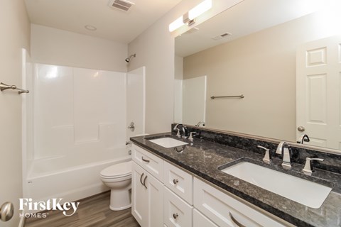 A bathroom with a white toilet, sink, and bathtub.