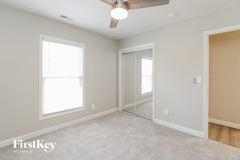 A room with a ceiling fan and a sliding door.