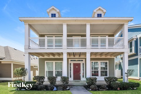 a white house with a porch and a red door