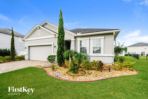 a white house with a lawn and a garden