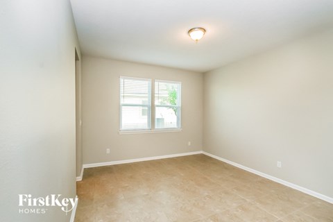 the spacious dining room with beige tile floors and a window