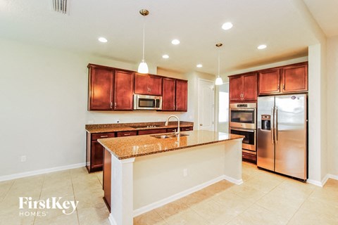 a kitchen with a large island and stainless steel appliances