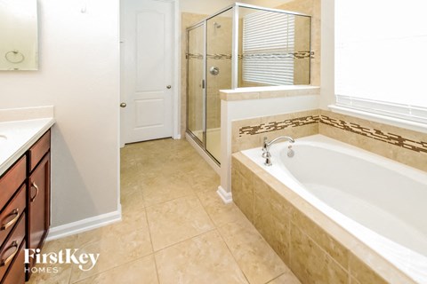 a bathroom with a tub and a shower and a sink