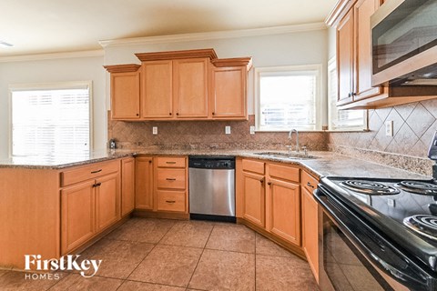 A kitchen with wooden cabinets and a stainless steel dishwasher.