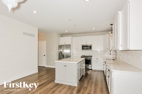 A modern kitchen with white cabinets and appliances.