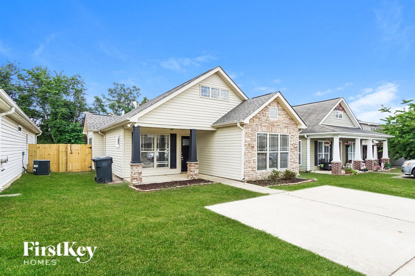 A house with a white front yard and a clear blue sky.