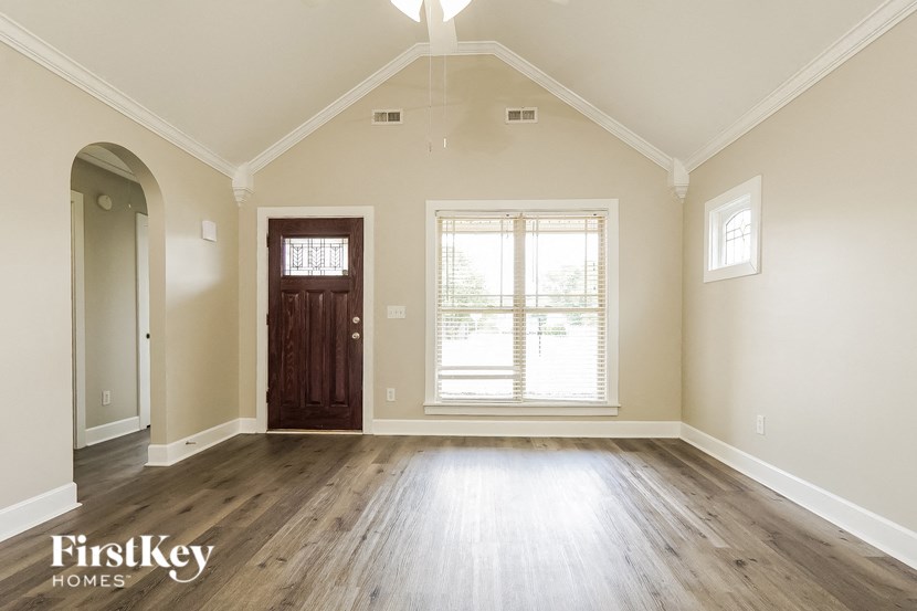 A room with a wooden floor and a brown door.