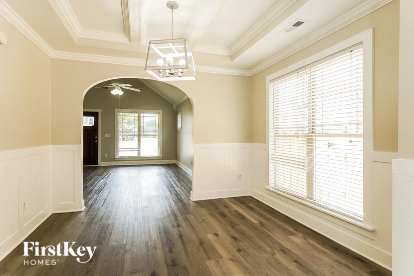 A spacious room with wooden floors and a large arched doorway.