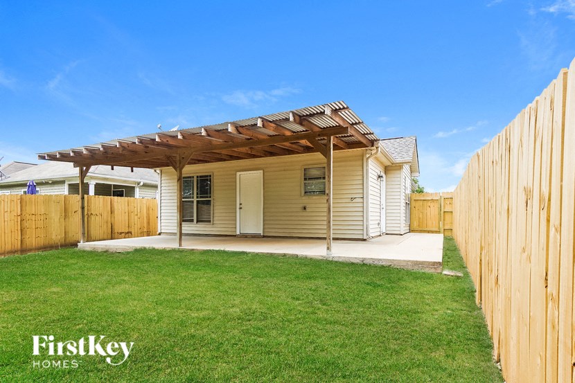 A house with a wooden fence and a covered patio area.