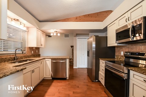 A kitchen with a stove top oven and a refrigerator.