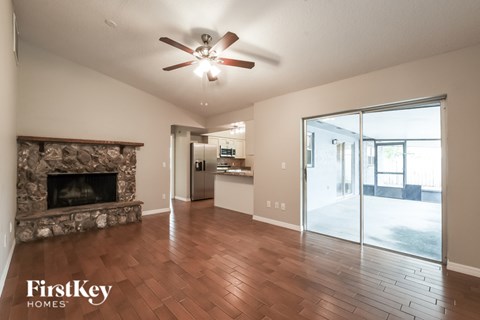 A spacious living room with a fireplace and wood flooring.