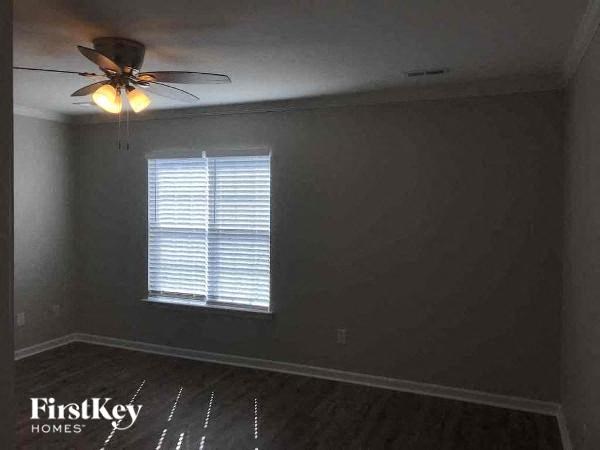 a empty room with a ceiling fan and a window