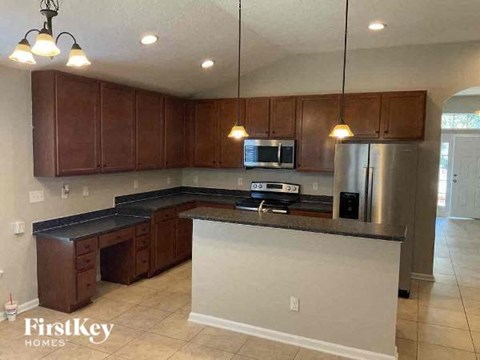 A kitchen with brown cabinets and a stainless steel refrigerator.