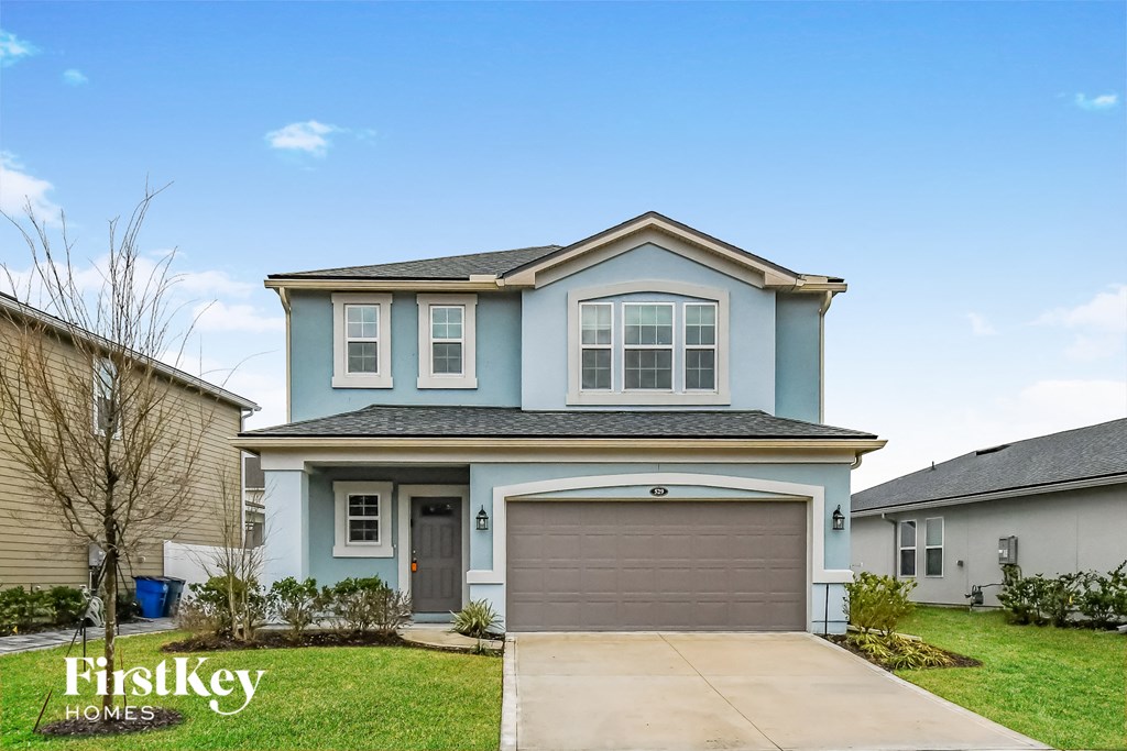 a blue house with a driveway and a garage door