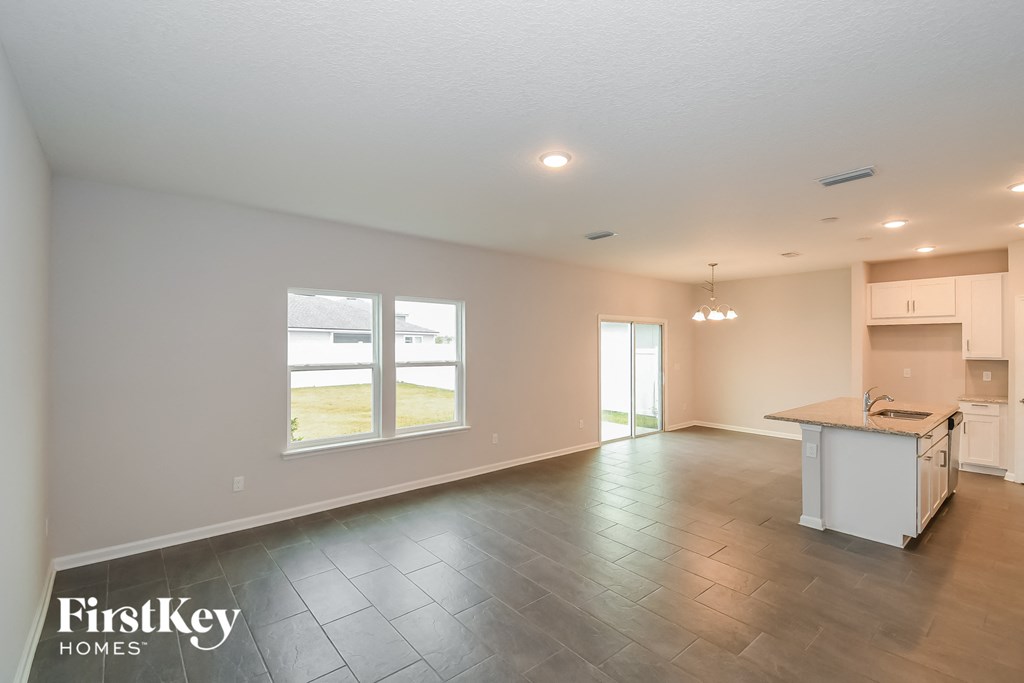 an empty living room and kitchen with a large window