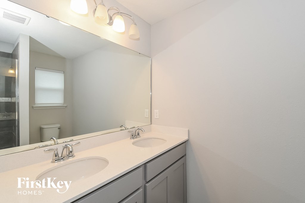 a bathroom with two sinks and a large mirror
