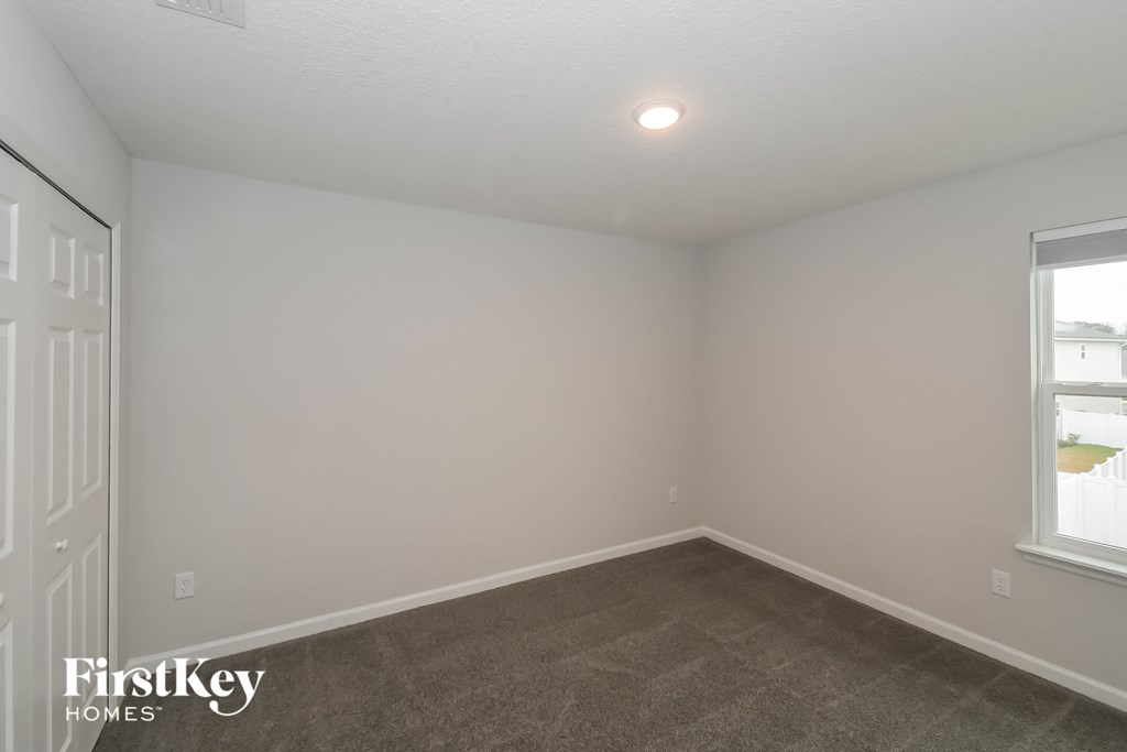 a bedroom with a carpeted floor and a window