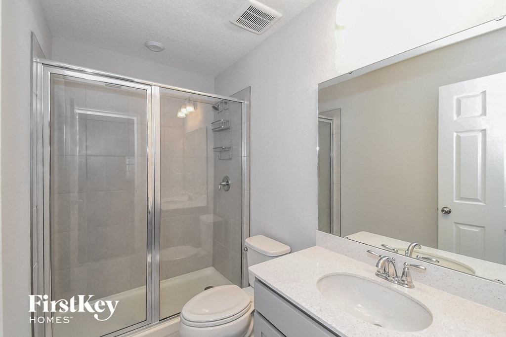 a bathroom with a shower and a sink and a mirror