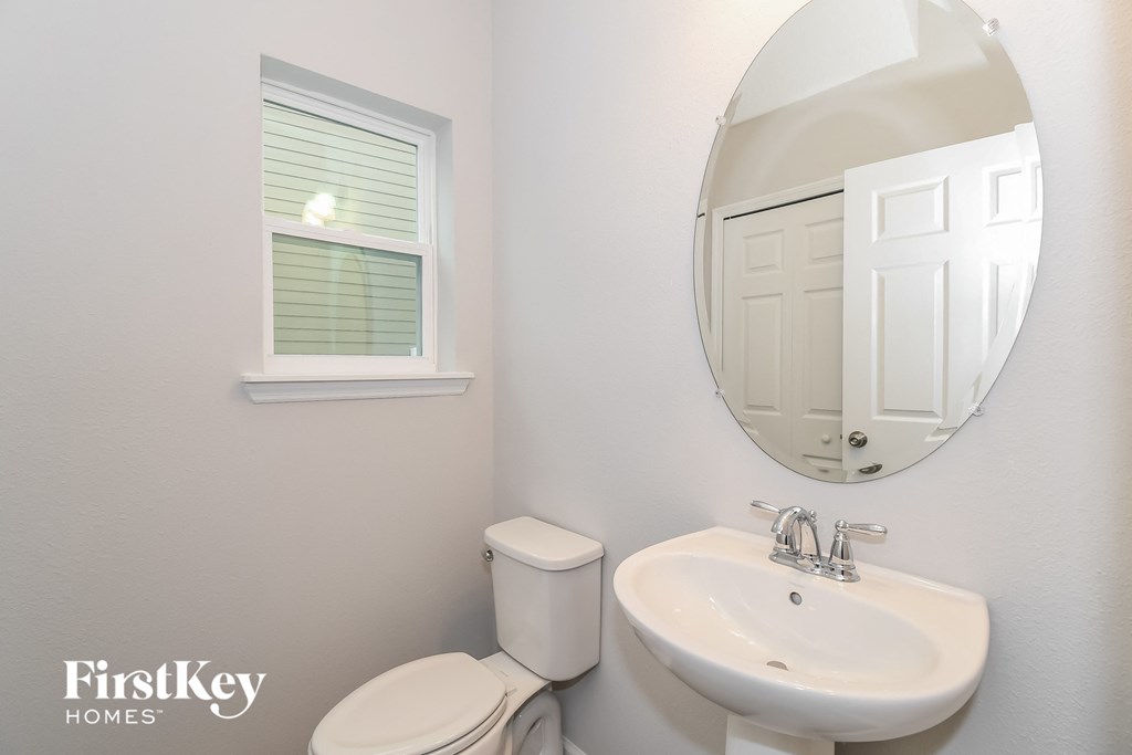a bathroom with a sink toilet and a mirror