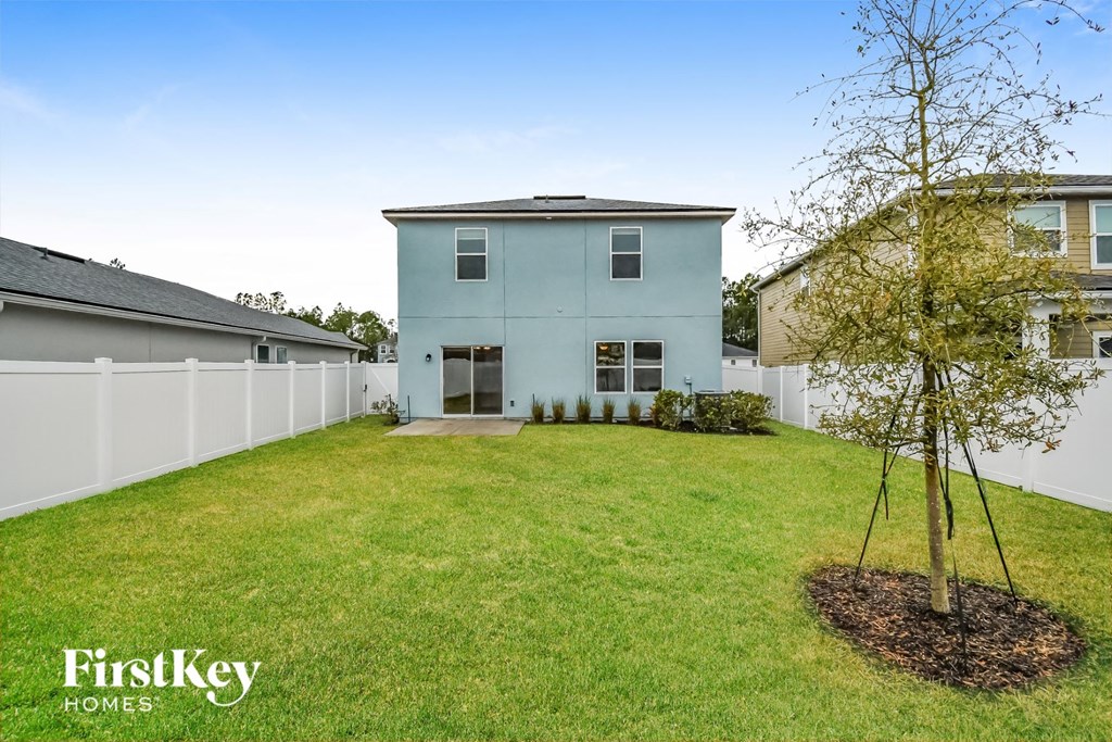a blue house with a yard and a tree