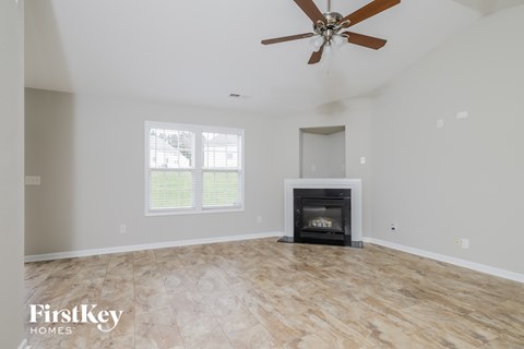 a living room with a fireplace and a ceiling fan