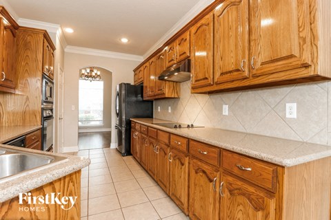 A kitchen with wooden cabinets and a granite countertop.
