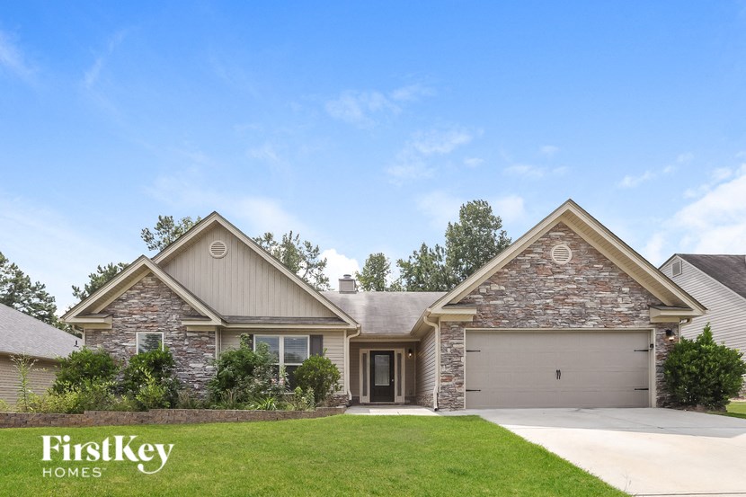 a home with stone exterior and a grassy yard