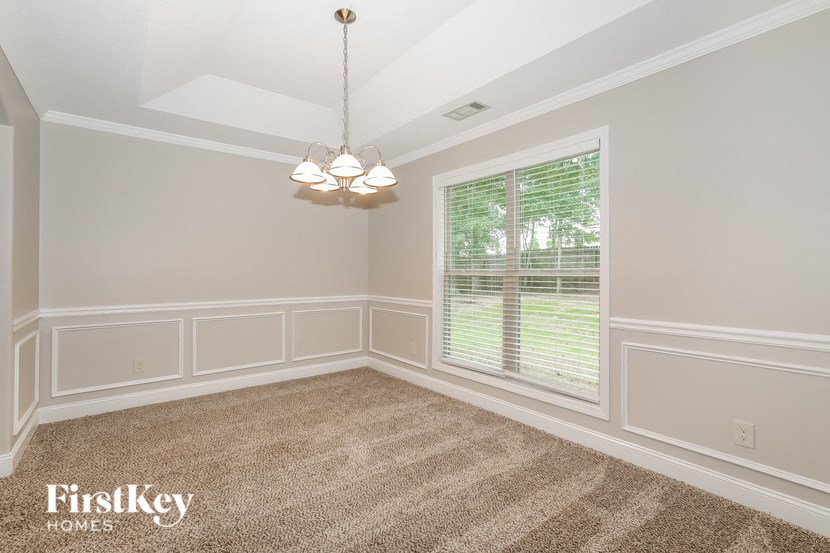a dining room with white walls and a window
