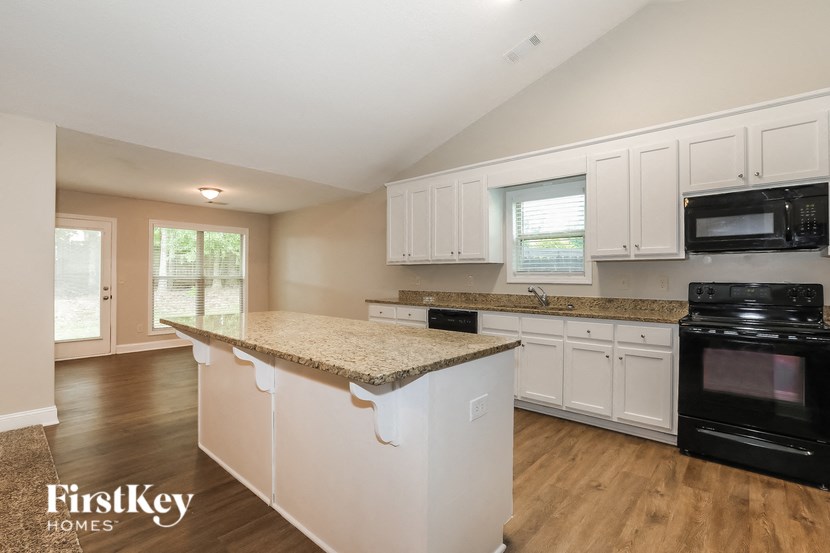 a kitchen with white cabinets and a granite counter top