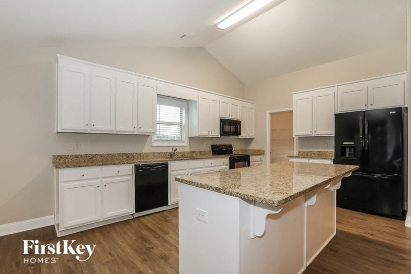a kitchen with white cabinets and a granite counter top