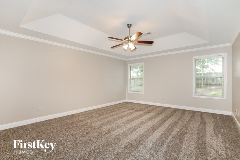 the living room of an empty house with a ceiling fan