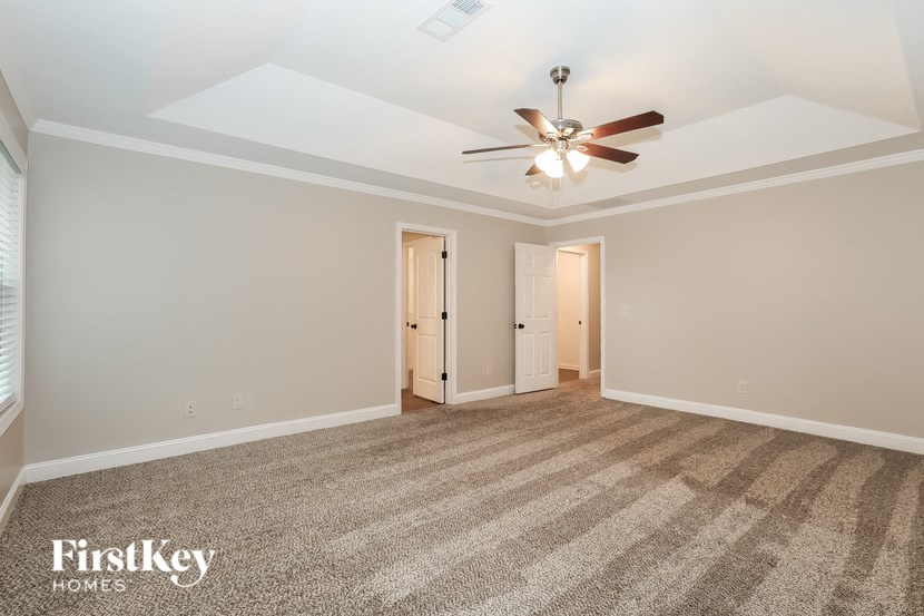 a living room with carpet and a ceiling fan