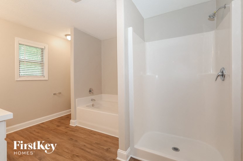 a bathroom with a tub and a shower and a window