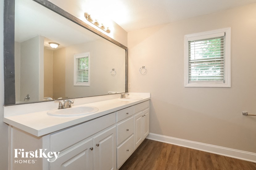 a bathroom with white cabinets and a sink and a mirror