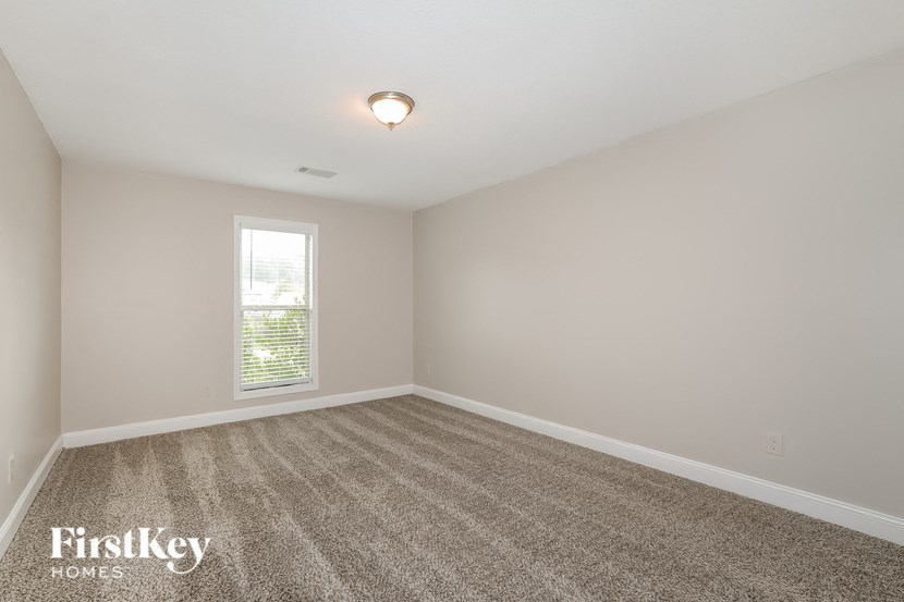 a empty room with carpet and a window