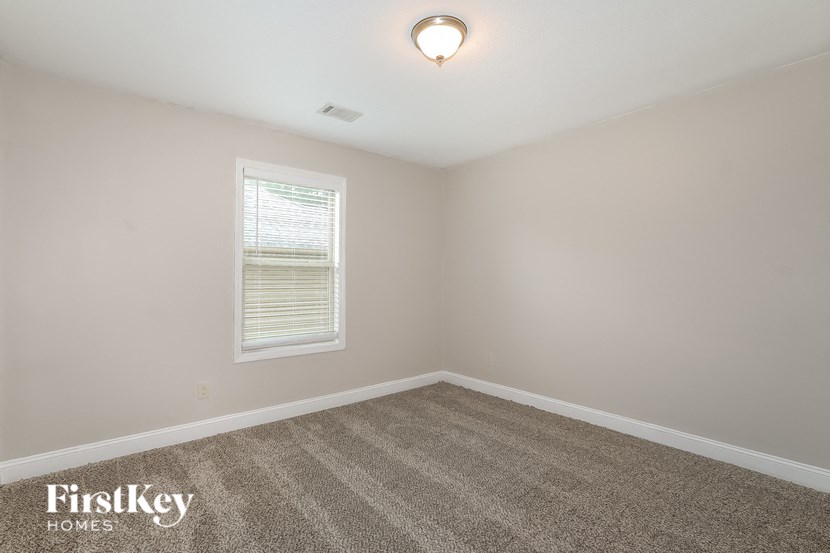 a empty room with carpet and a window