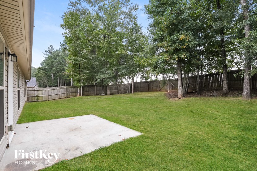 a backyard with a yard and a fence and trees