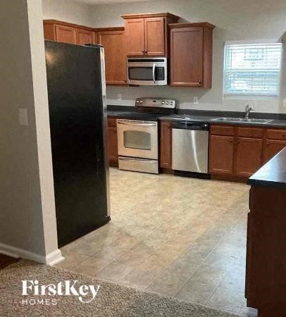 A kitchen with a black fridge, microwave, oven and dishwasher.