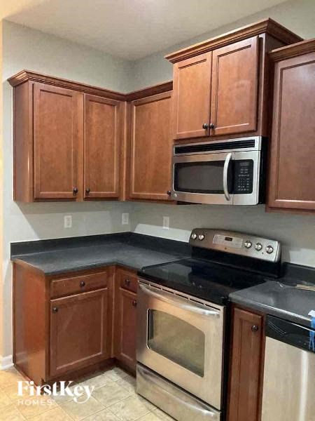 A kitchen with wooden cabinets and a black countertop.