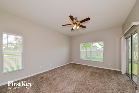 a living room with carpet and a ceiling fan