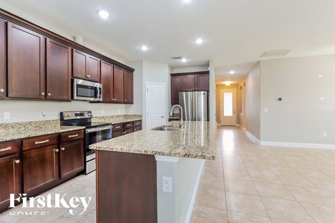 A kitchen with brown cabinets and granite countertops.