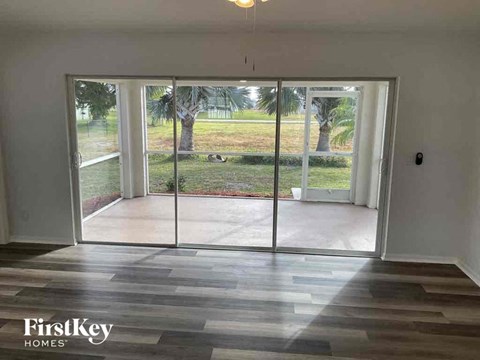 a living room with a view of a yard and glass doors