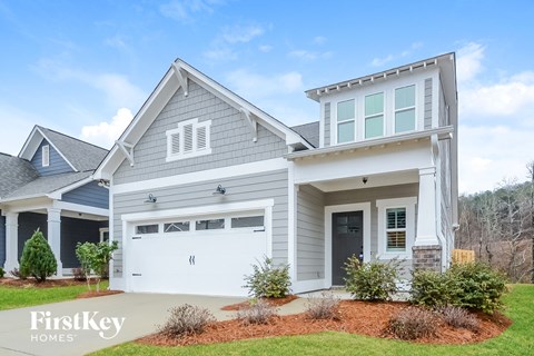 A house with a garage and a driveway in front.