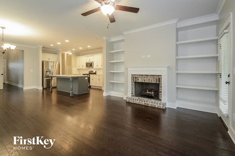 A spacious living room with a fireplace and built-in shelves.