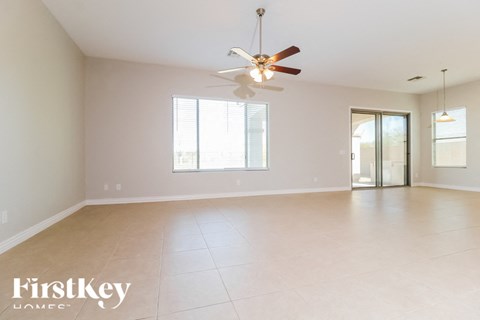 A spacious room with a ceiling fan and sliding glass doors.