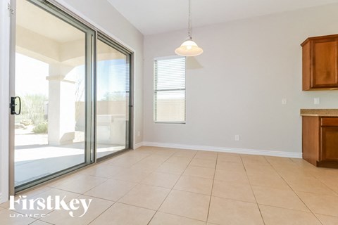 A room with a sliding glass door leading to a balcony, a ceiling light, and a wooden cabinet.